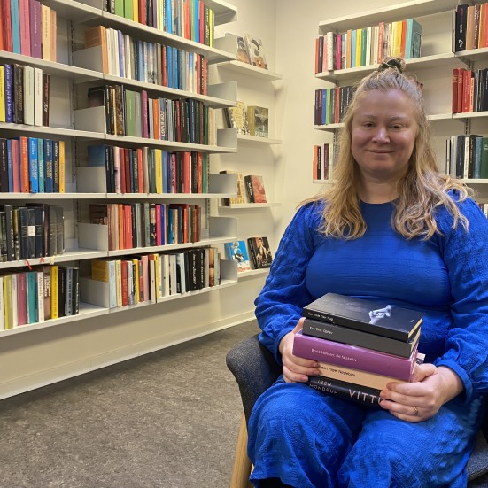 Bibliotekar med en stak af biblioteksbøger