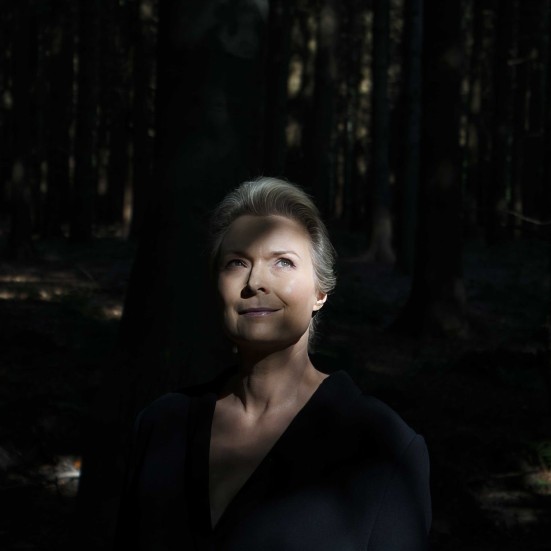 Forfatterportræt Helle Helle: står i lysningen i en skov