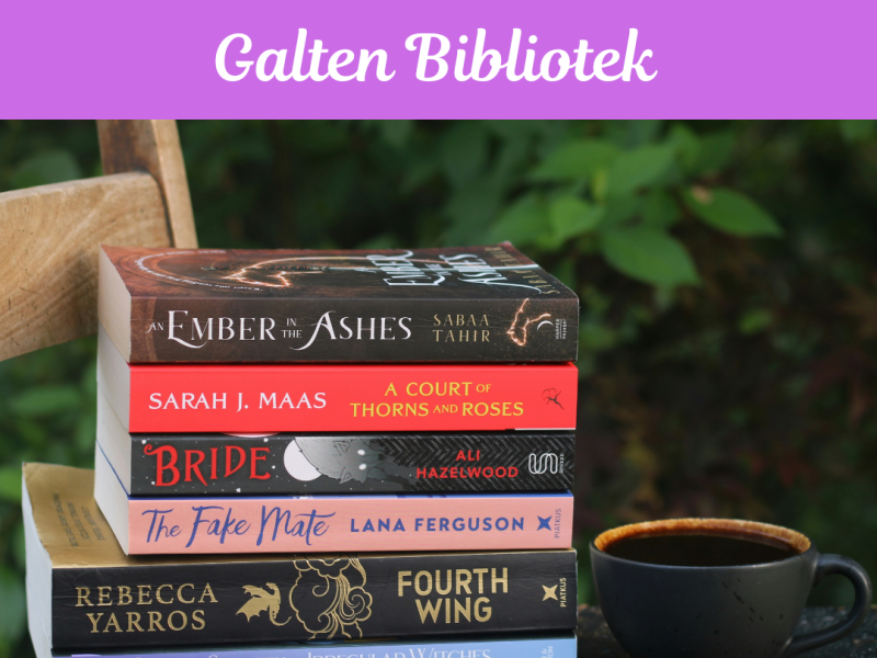 Stak af romantasybøger ved siden af en kaffekop