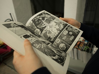 To hænder holder en åben manga-bog.