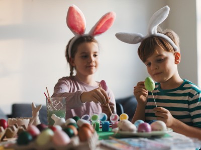 2 børn med kaninører maler påskeæg