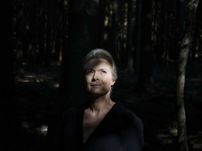 Forfatterportræt Helle Helle: står i lysningen i en skov