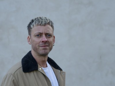 Forfatteren Theis Ørntoft foran en grå mur