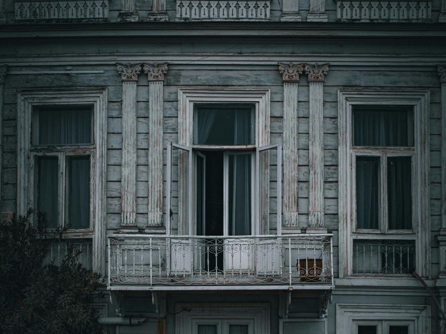 En mørk bygning med en åben terrassedør. 