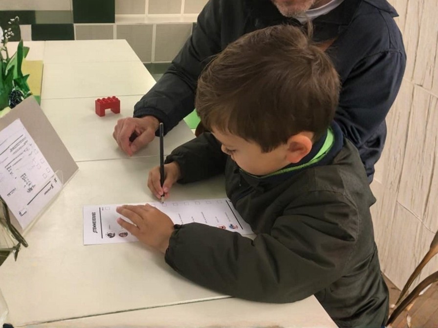 Dreng udfylder stemmeseddel til Børnevalget.